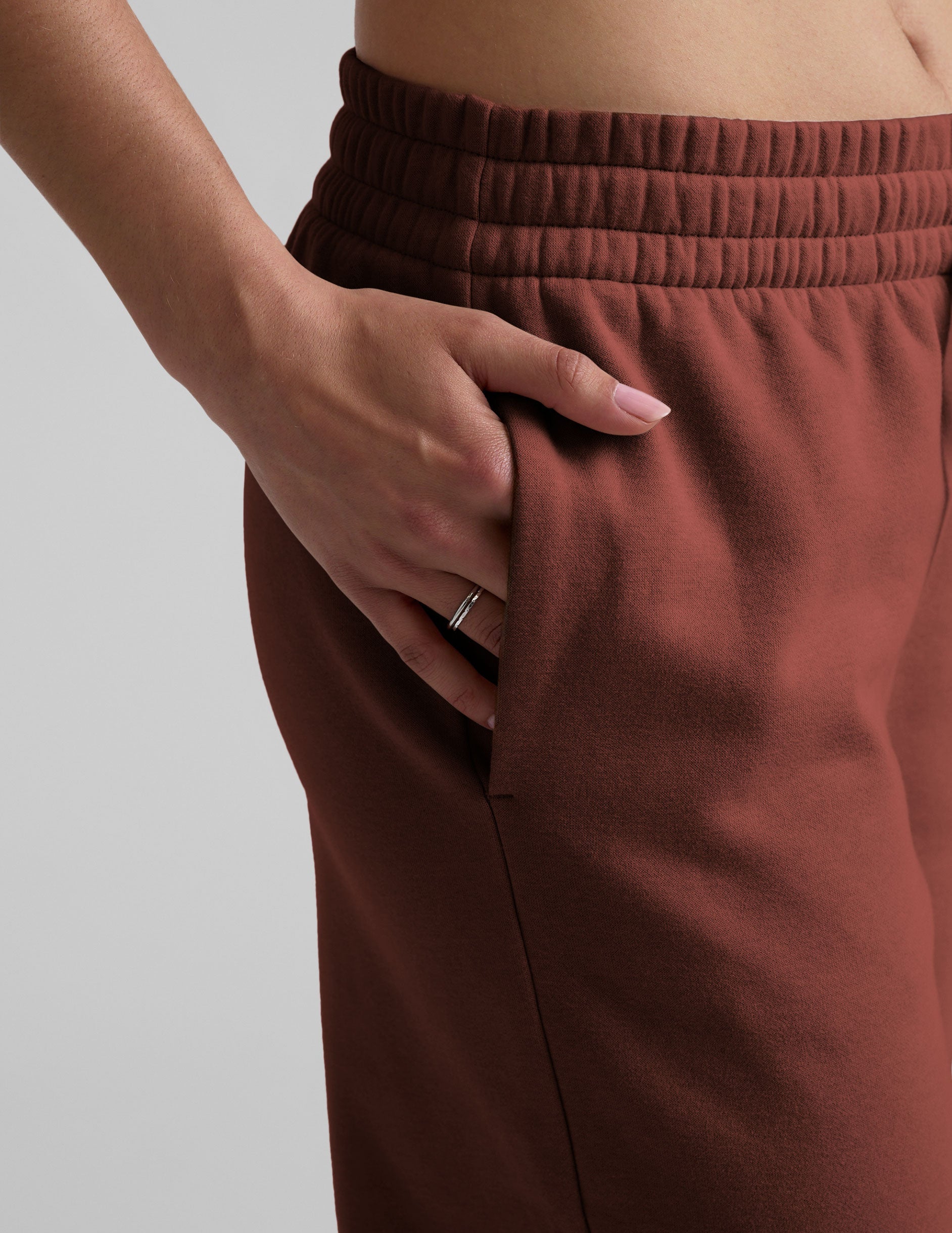 brown mid-rise wide leg sweatpants with side slits and a drawcord at waistband.