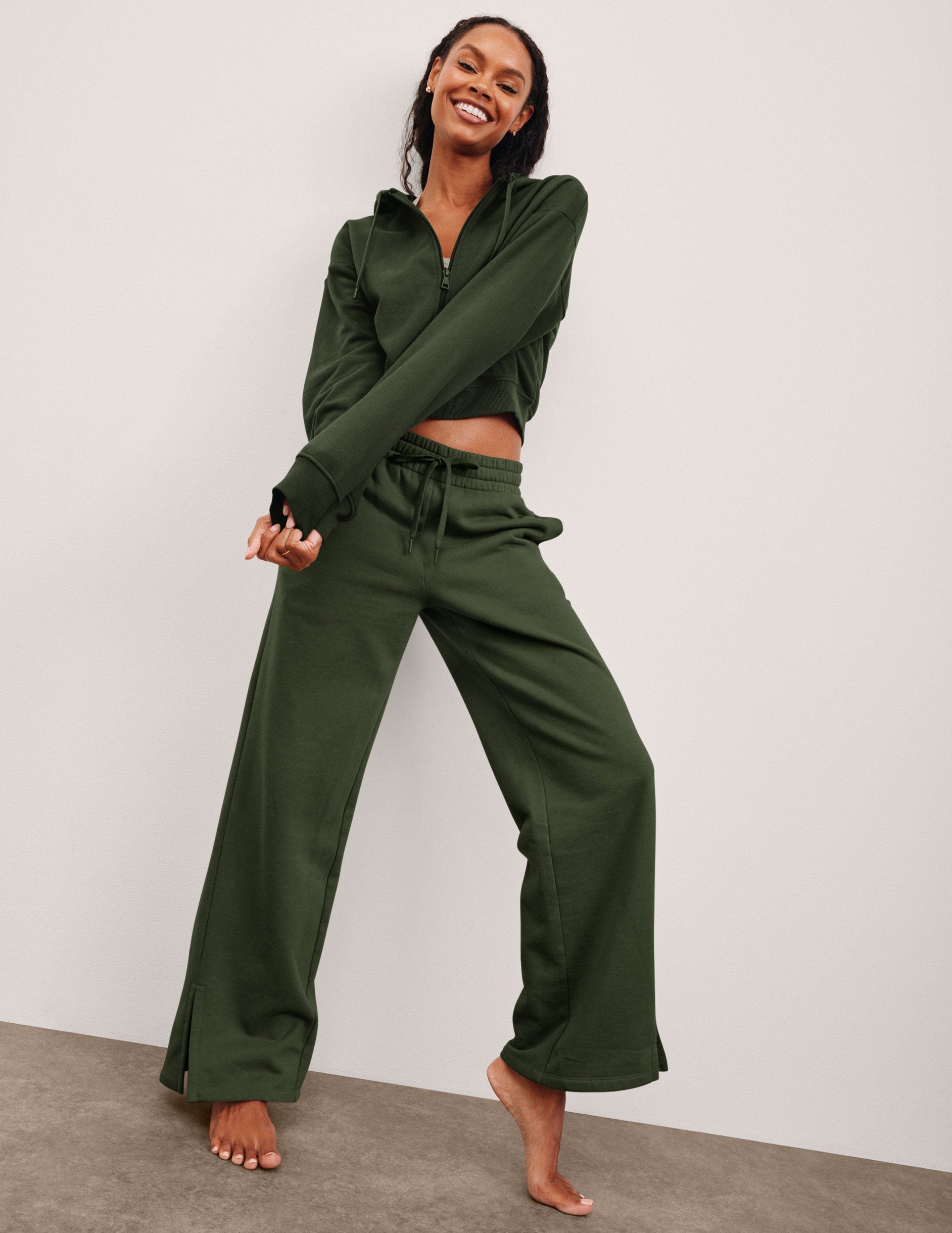green mid-rise wide leg sweatpants with side slits and a drawcord at waistband.