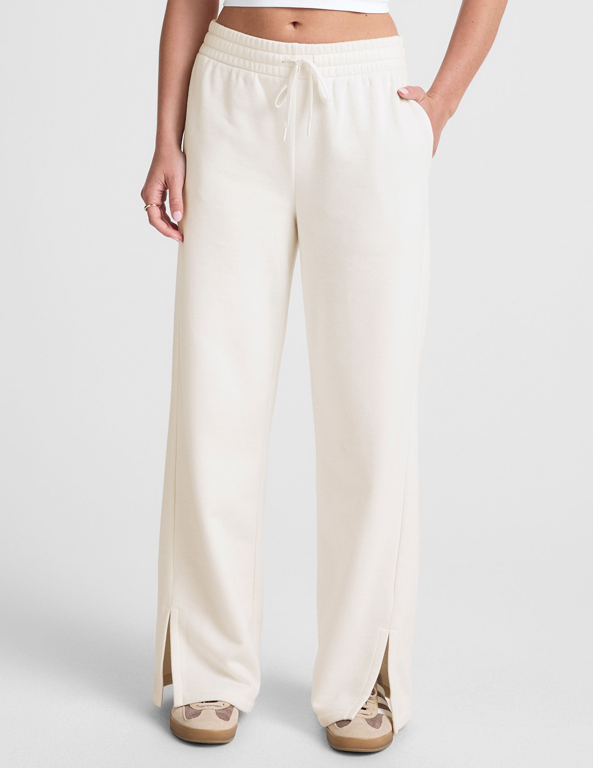 white mid-rise wide leg sweatpants with side slits and a drawcord at waistband.