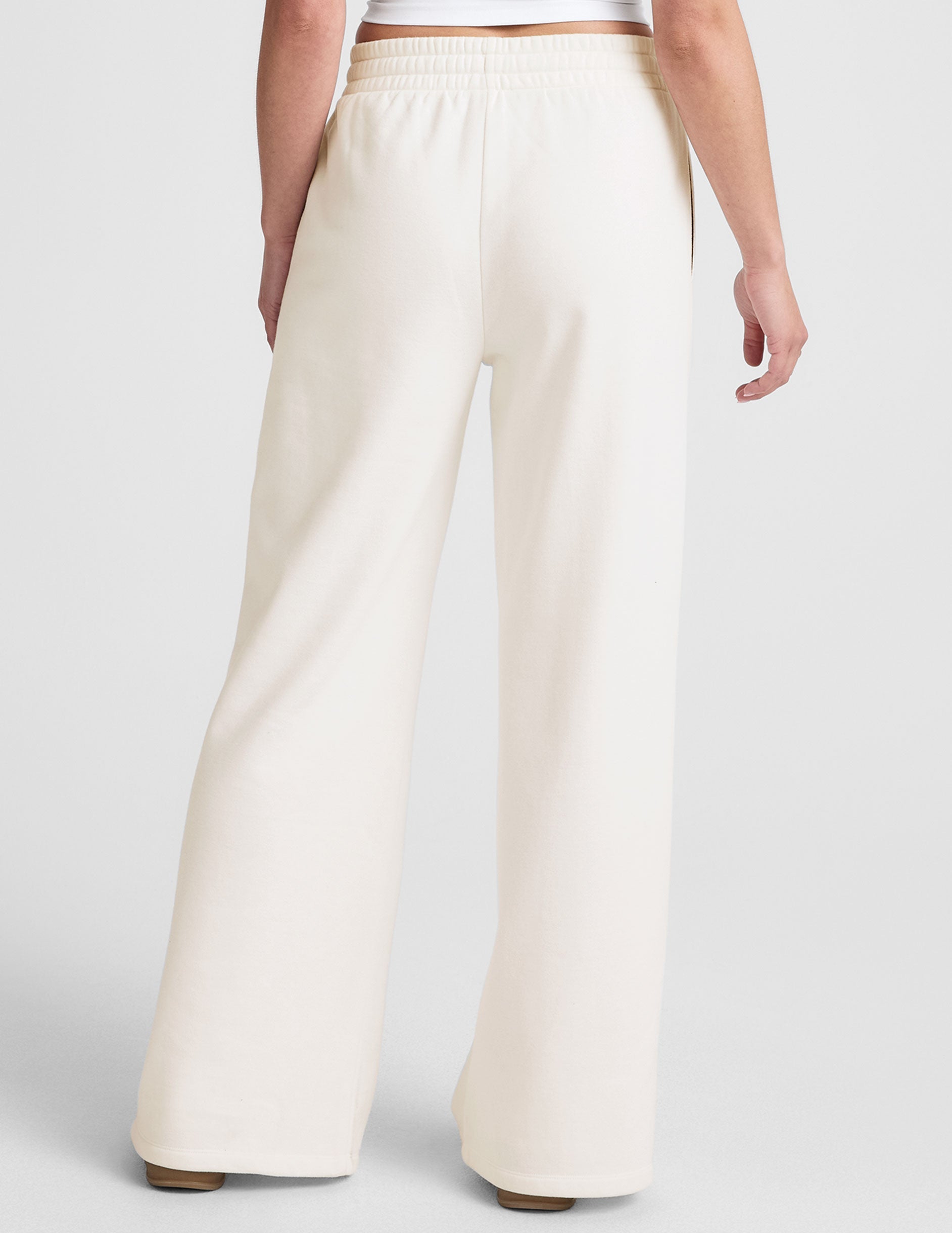 white mid-rise wide leg sweatpants with side slits and a drawcord at waistband.
