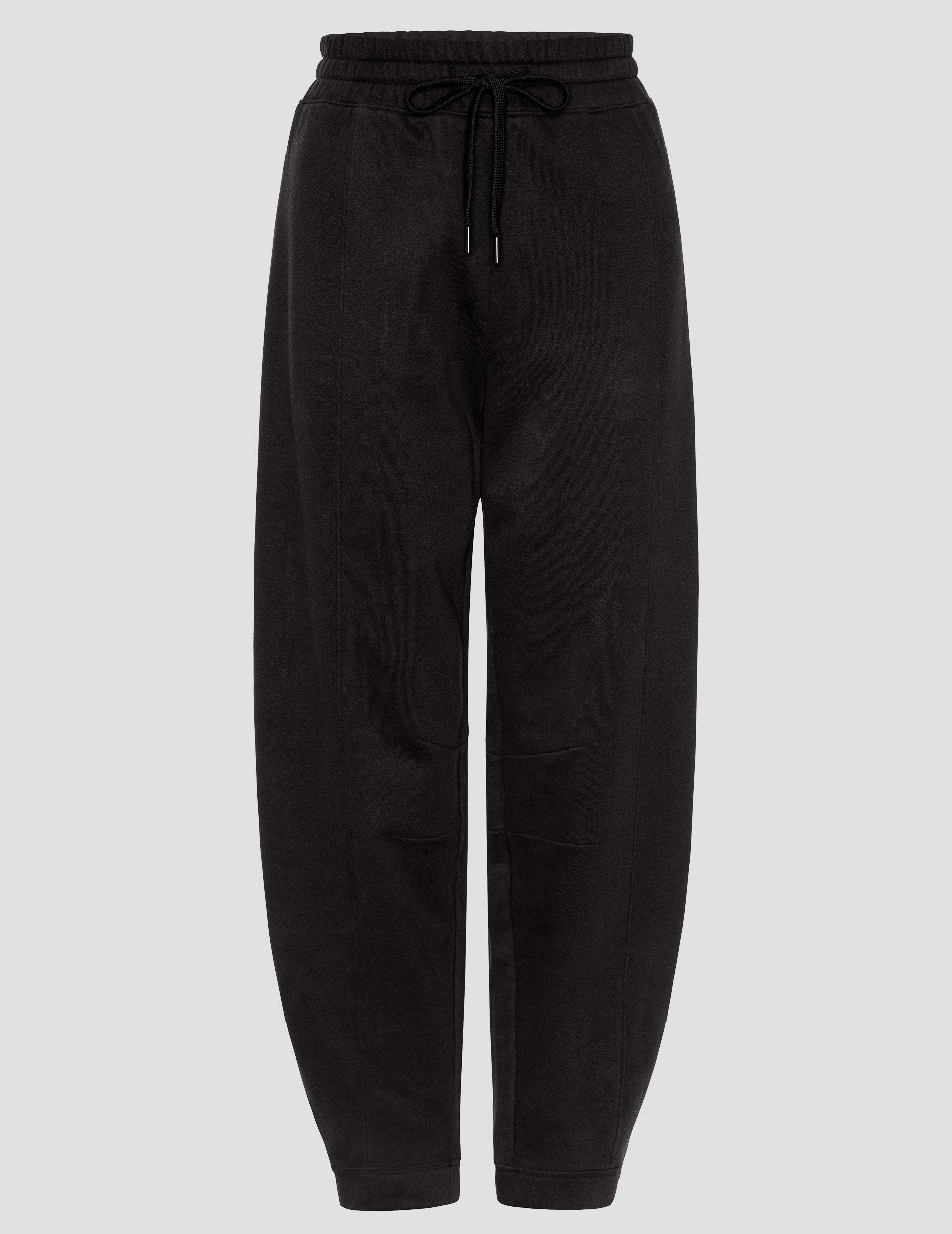 black fleece barrel style sweatpants against a plain background.