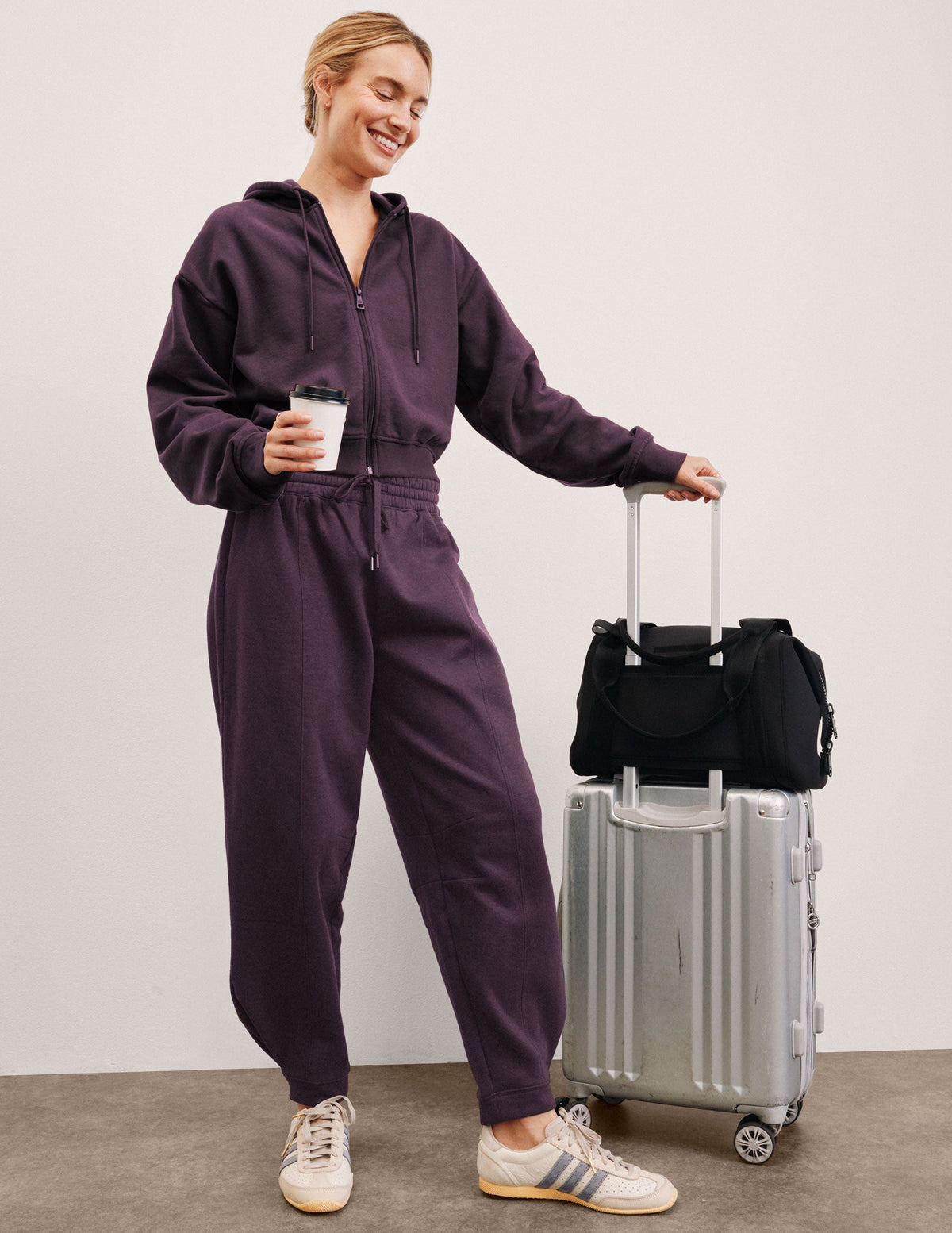 model is wearing purple fleece barrel style fleece sweatpants against a plain background.