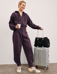 model is wearing purple fleece barrel style fleece sweatpants against a plain background.