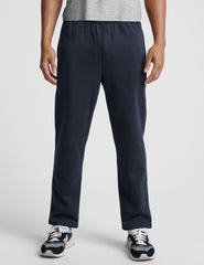 man wearing navy blue straight leg fleece sweatpants on a plain background.
