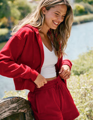 red fleece zip-up jacket with a drawstring hood.