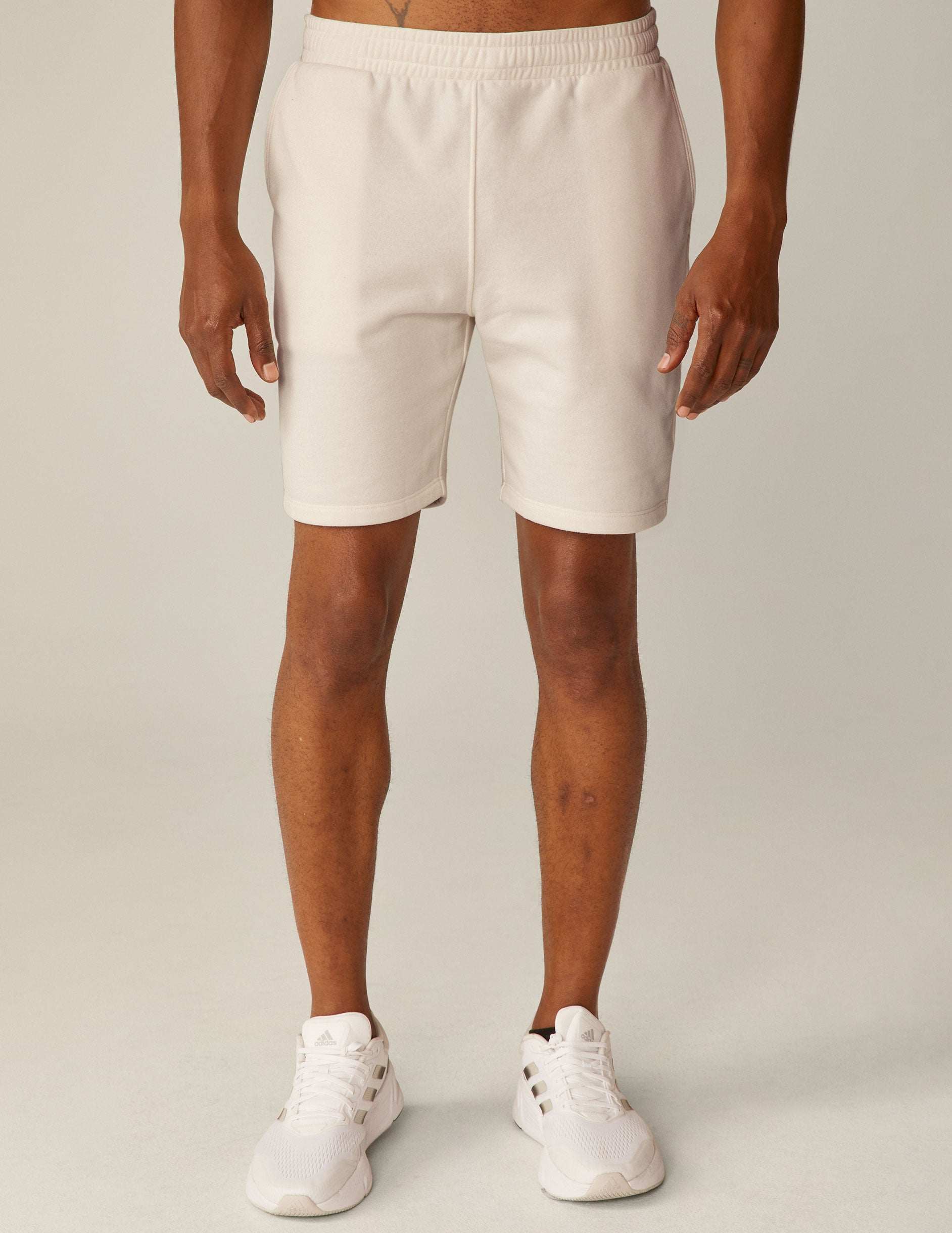 model is wearing white men's sweatshorts with pockets.