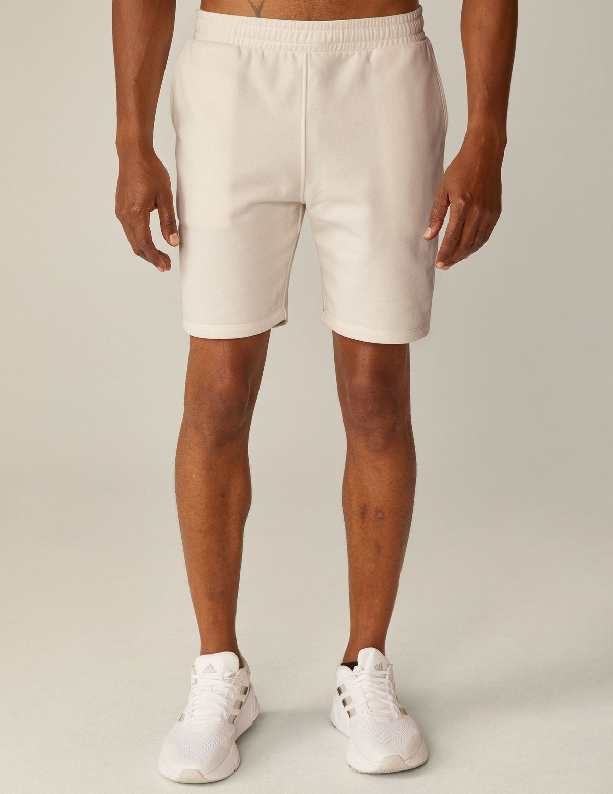 model is wearing white men's sweatshorts with pockets.