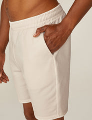 model is wearing white men's sweatshorts with pockets.