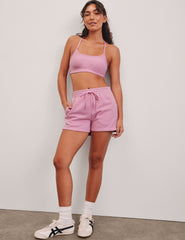 pink sweat shorts with pockets and a drawstring at waistband.