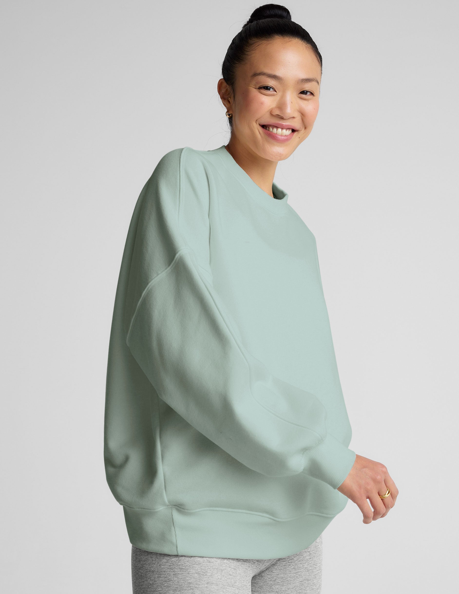 model wearing a light blue oversized crew neck fleece sweatshirt against a plain background.