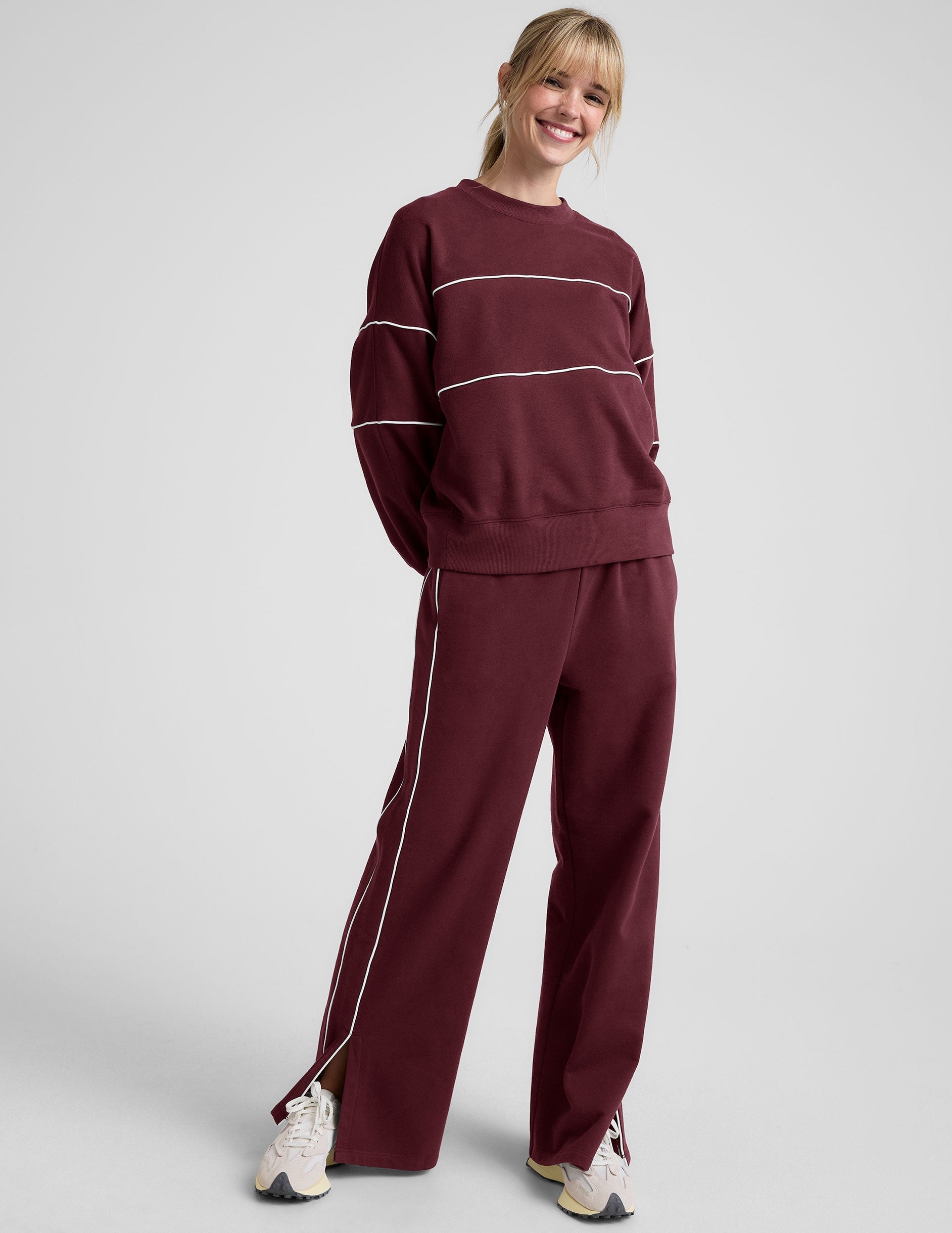 red fleece crewneck sweater with white contrast piping trim at chest and sleeves.