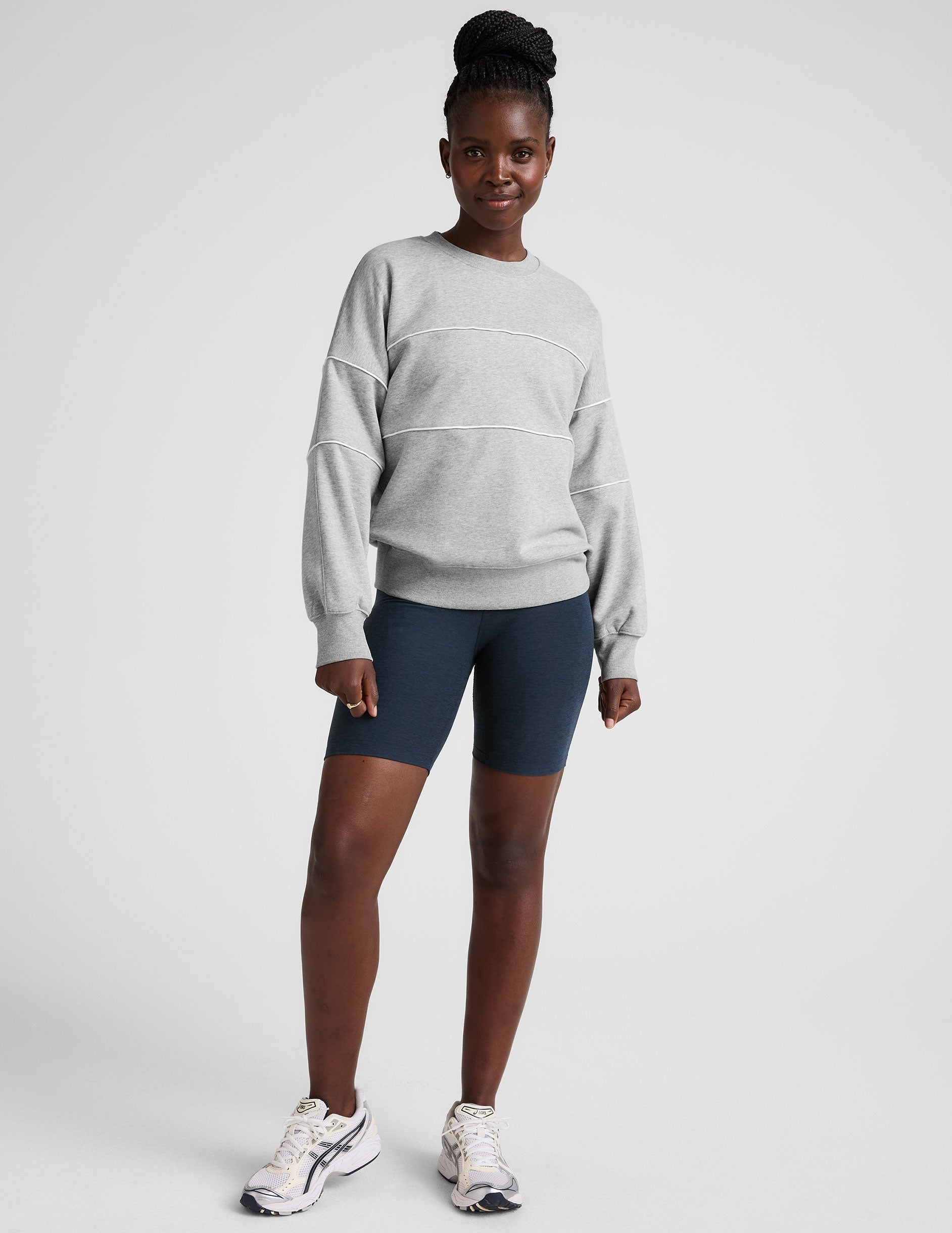gray fleece crewneck sweater with white contrast piping trim at chest and sleeves.