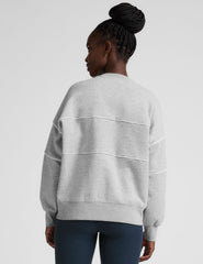 gray fleece crewneck sweater with white contrast piping trim at chest and sleeves.