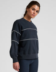 blue fleece crewneck sweater with white contrast piping trim at chest and sleeves.