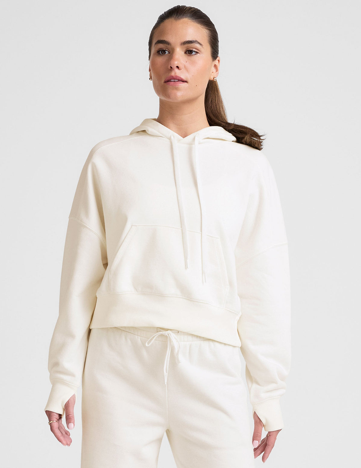 white cropped pullover with a hood with drawcord and a kangaroo pocket.