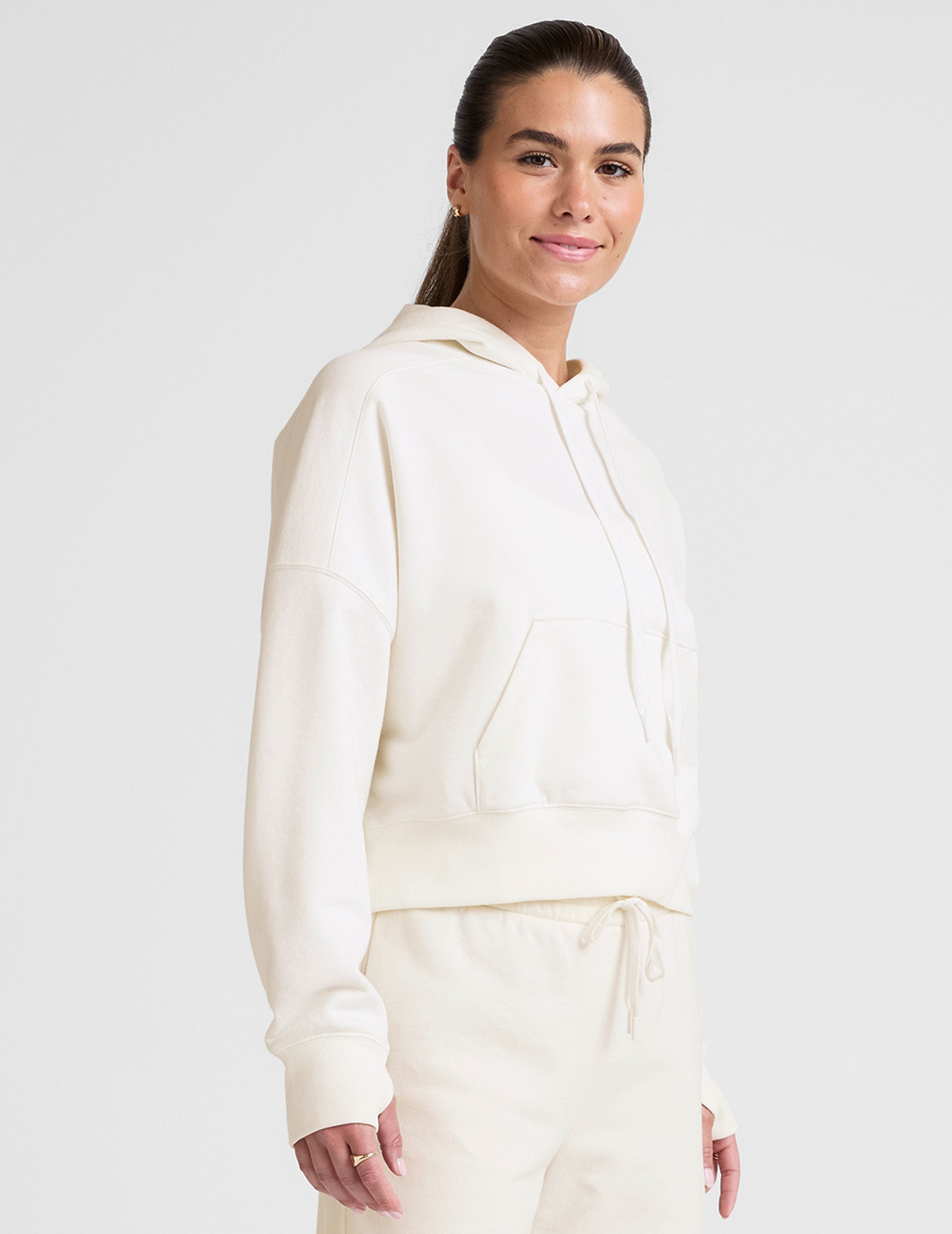 white cropped pullover with a hood with drawcord and a kangaroo pocket.