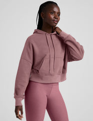 pink cropped pullover with a hood with drawcord and a kangaroo pocket.