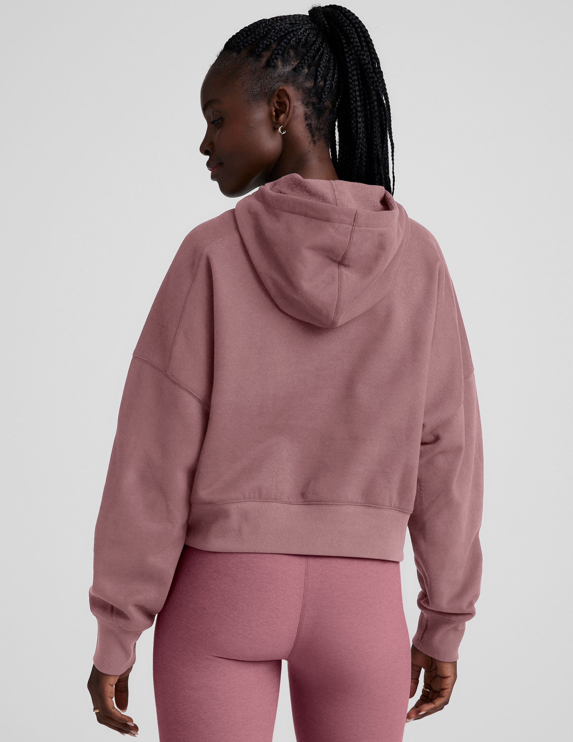 pink cropped pullover with a hood with drawcord and a kangaroo pocket.