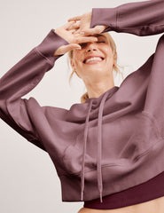 pink cropped pullover with a hood with drawcord and a kangaroo pocket.