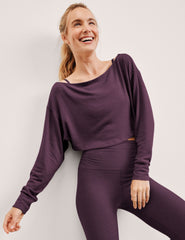 model wearing a purple shrug and purple leggings on a light background.