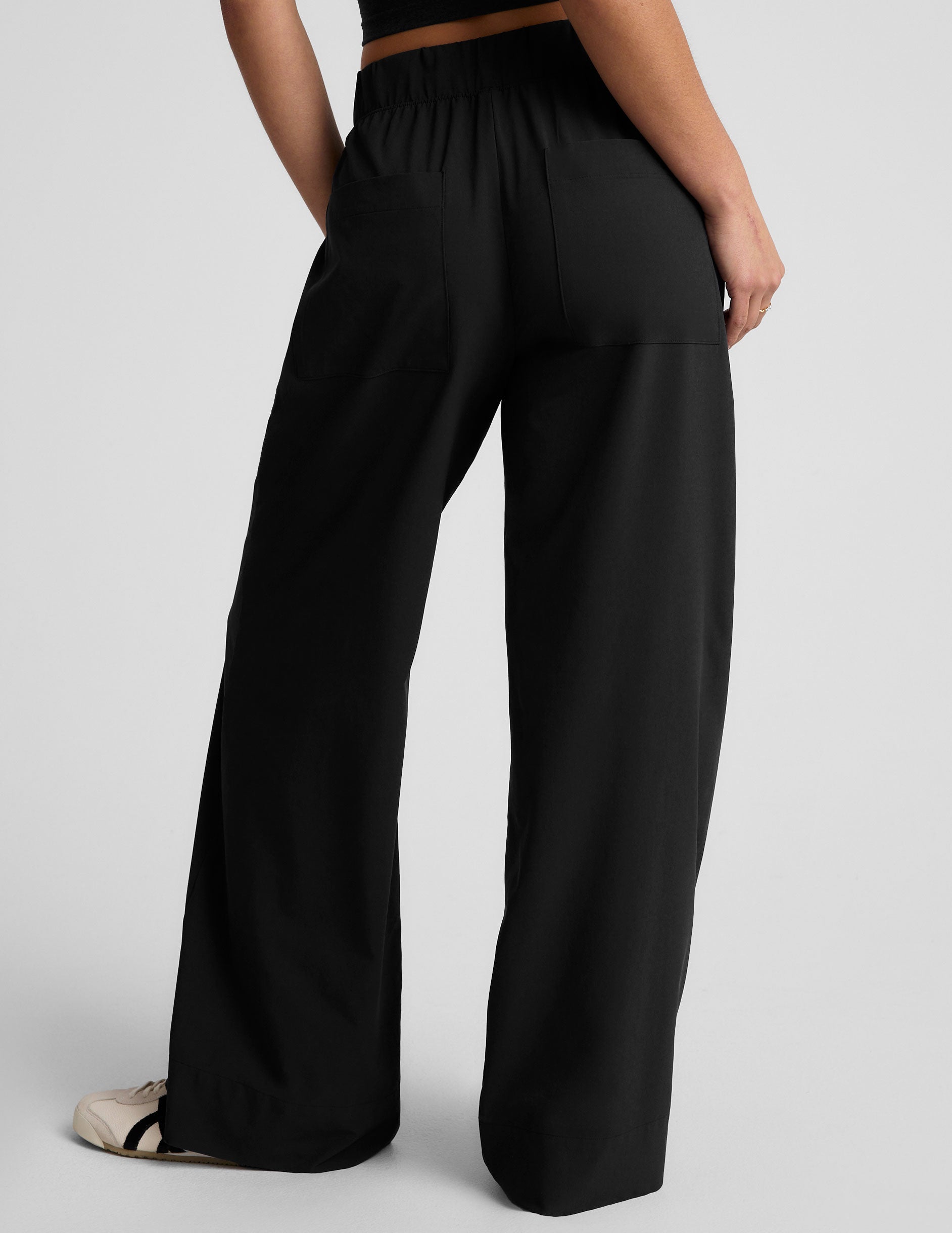 black mid rise relaxed fit wide leg pant with front side seam pockets and back pockets.
