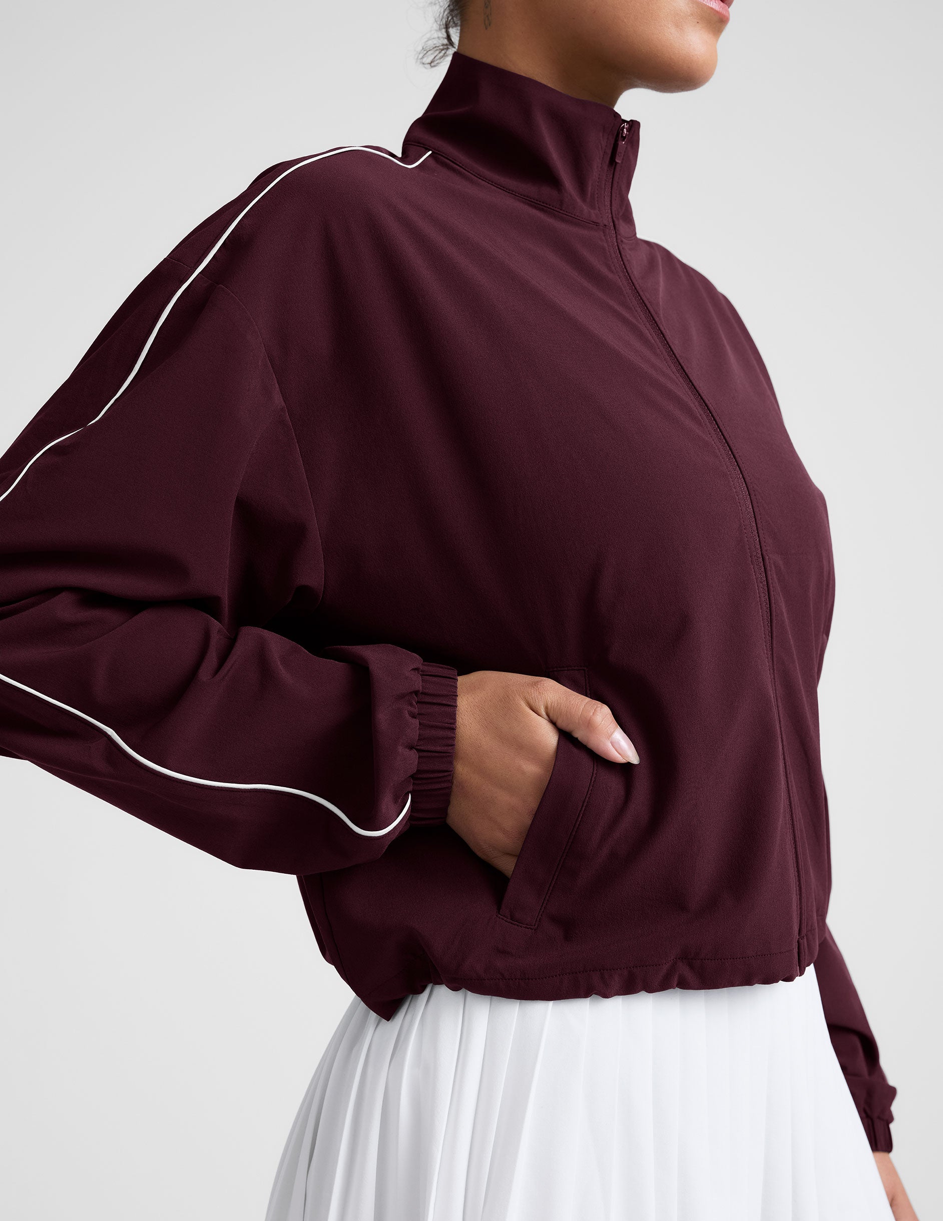 red zip-up jacket with white piping and pockets.