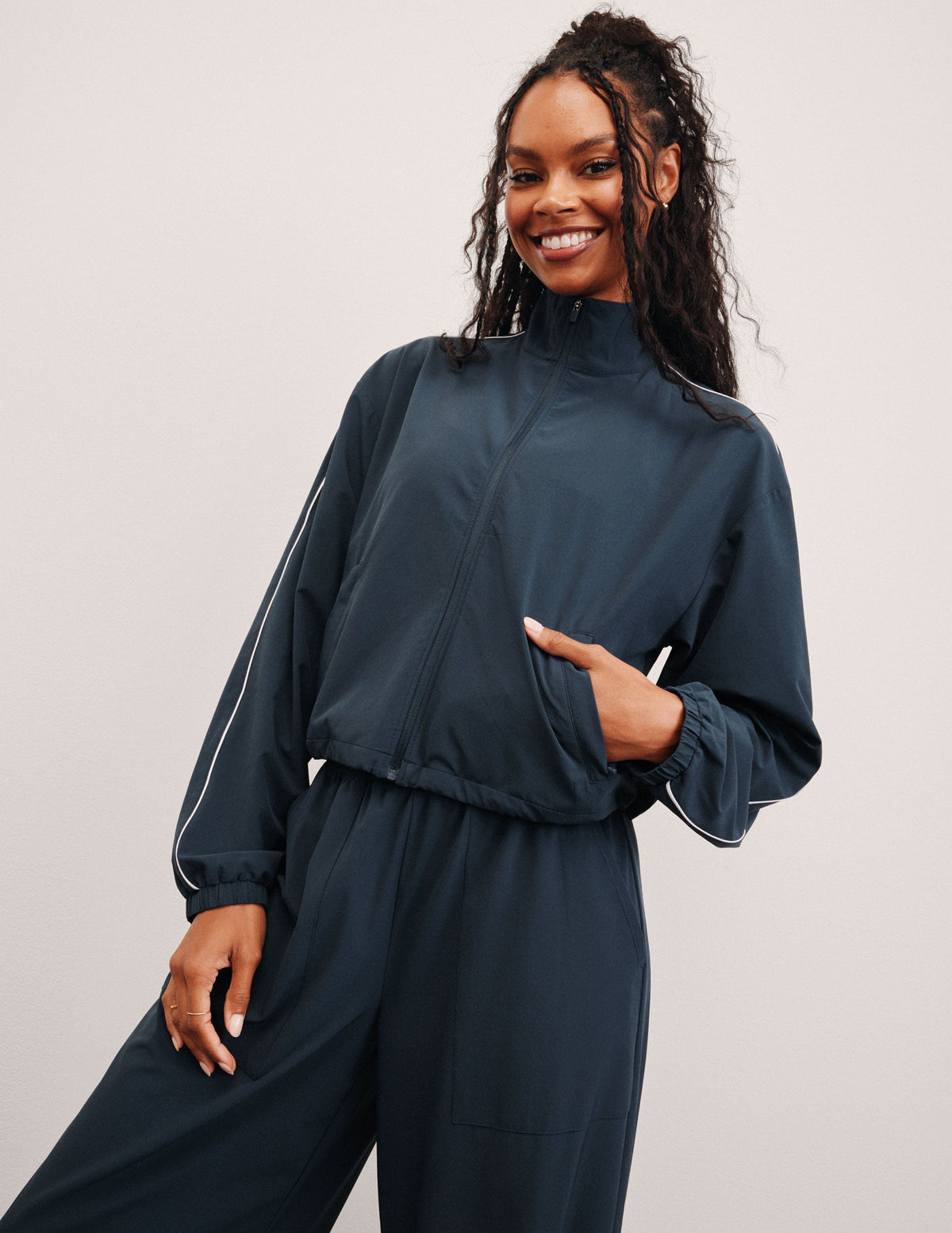 blue zip-up jacket with pockets and white trim detailing.