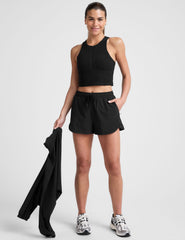 black shorts with a 2.5" inseam, encased elastic at waistband with drawcord​, self binding at hem edges​, side zipper pockets, and interior performance lining shorts​. 