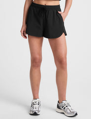black shorts with a 2.5" inseam, encased elastic at waistband with drawcord​, self binding at hem edges​, side zipper pockets, and interior performance lining shorts​. 