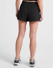 black shorts with a 2.5" inseam, encased elastic at waistband with drawcord​, self binding at hem edges​, side zipper pockets, and interior performance lining shorts​. 