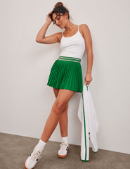 green pleated mini skirt with an exposed stripped elastic waistband​ and internal performance shorts with pockets​.