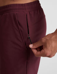 man wearing a grey t-shirt and maroon lined shorts set on a white background.