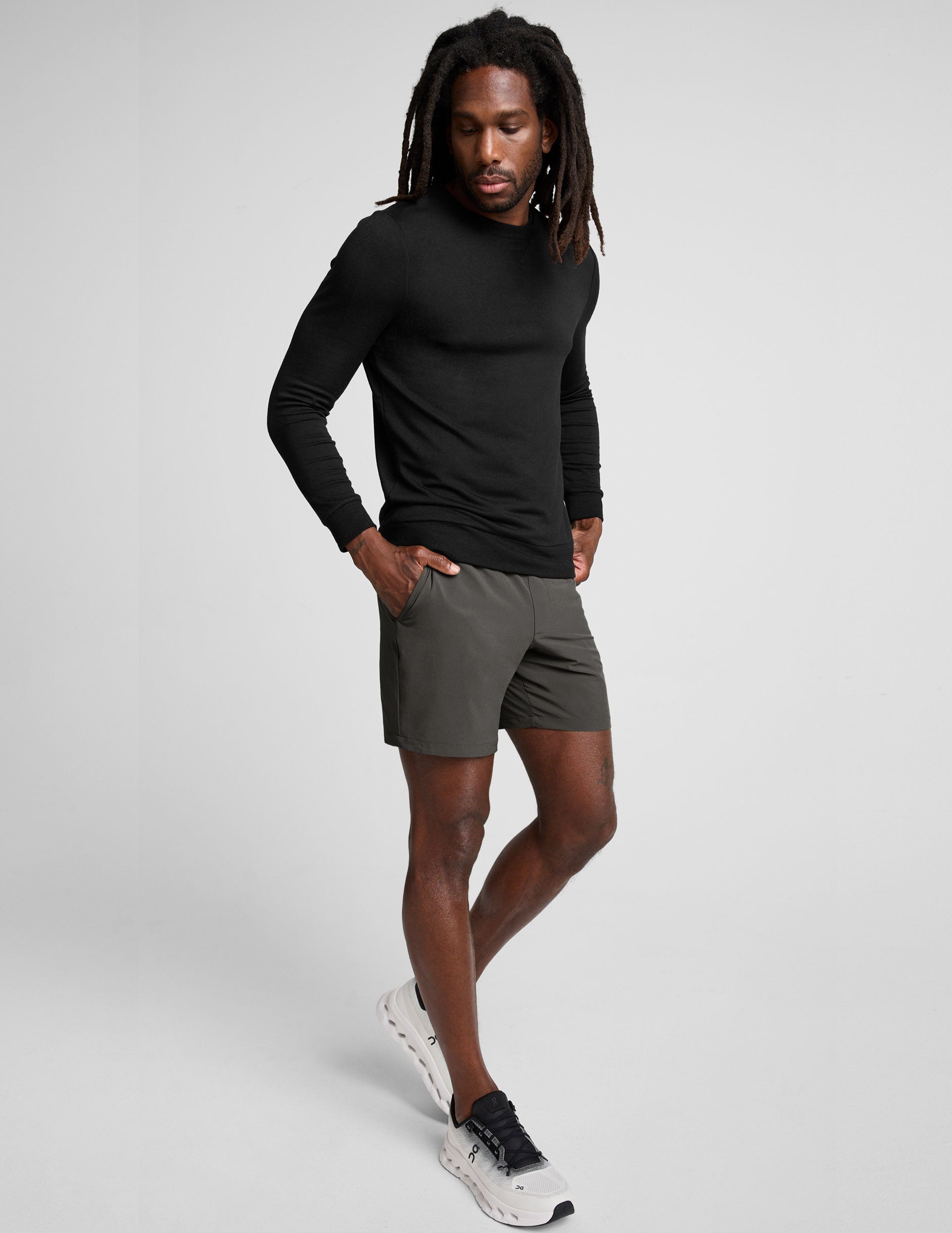 man wearing a long sleeve and graphite shorts on a white background.
