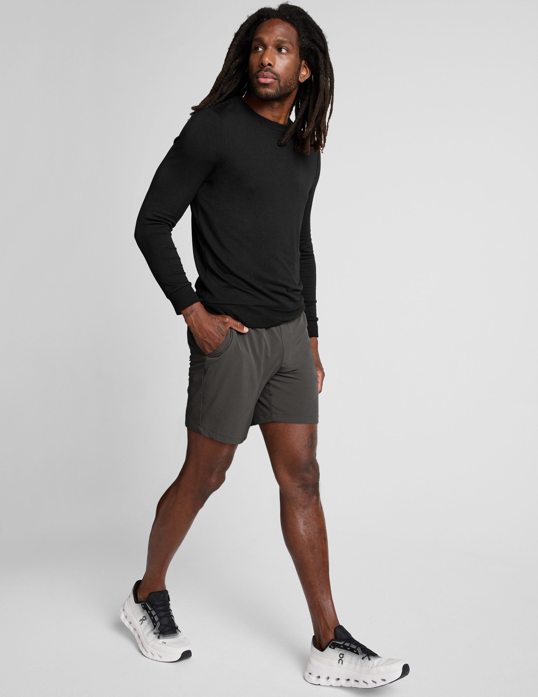 man wearing a long sleeve and graphite shorts on a white background.