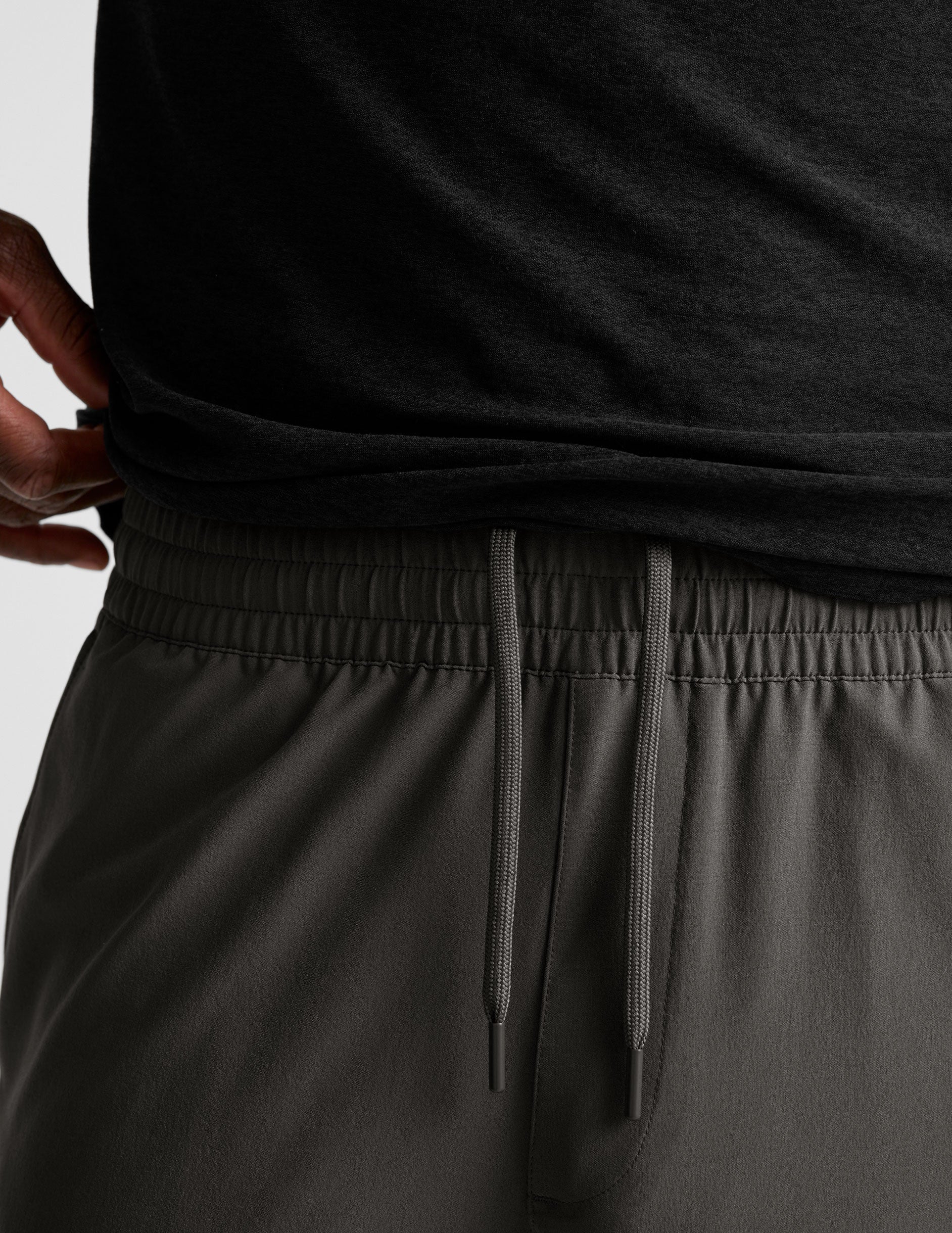 man wearing a long sleeve and graphite shorts on a white background.