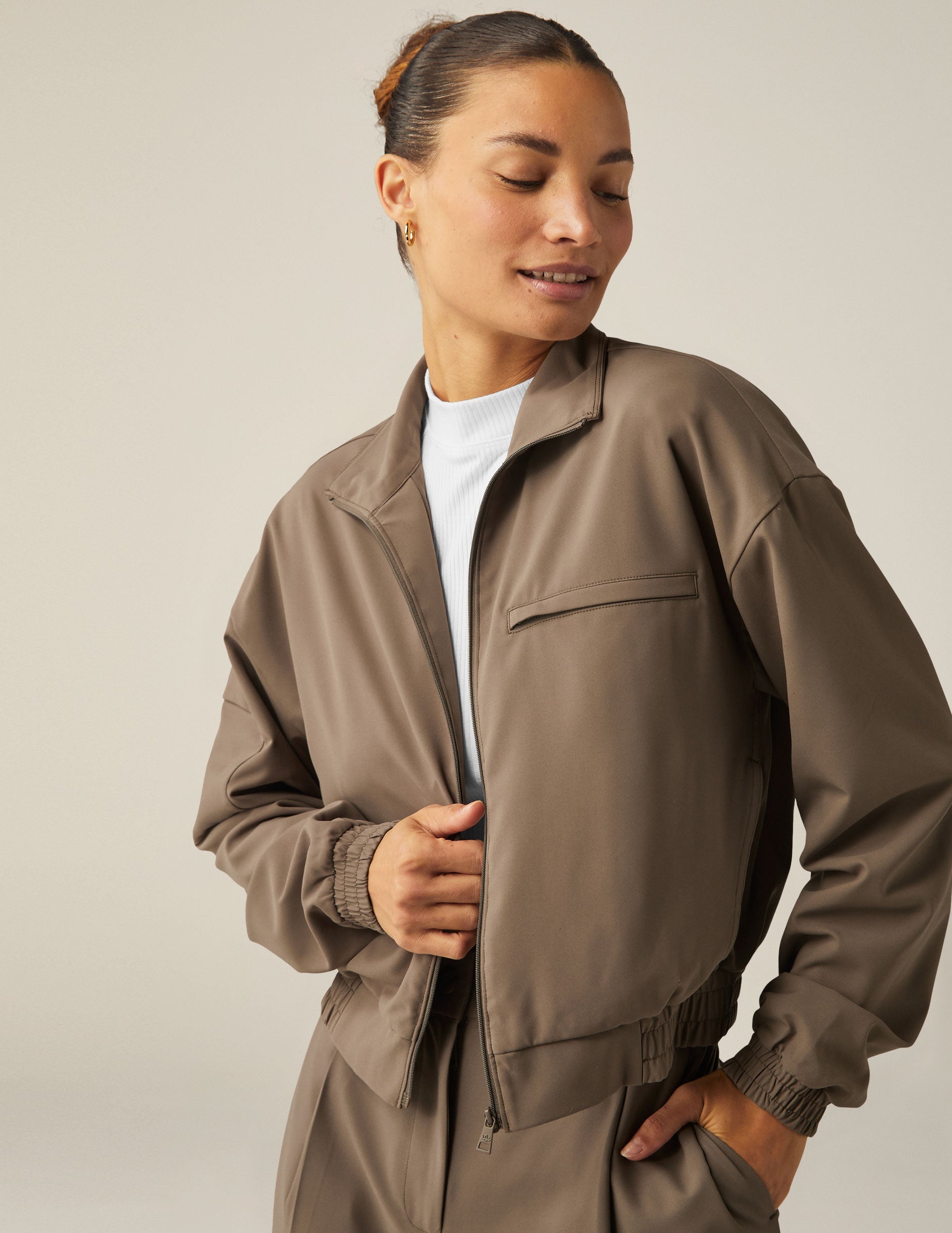 brown zip-up jetstretch woven jacket with a collar and pockets.
