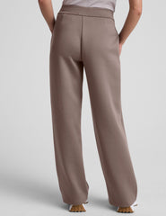 model is wearing brown spacer style pants with pockets against a plain background.