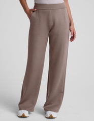 model is wearing brown spacer style pants with pockets against a plain background.
