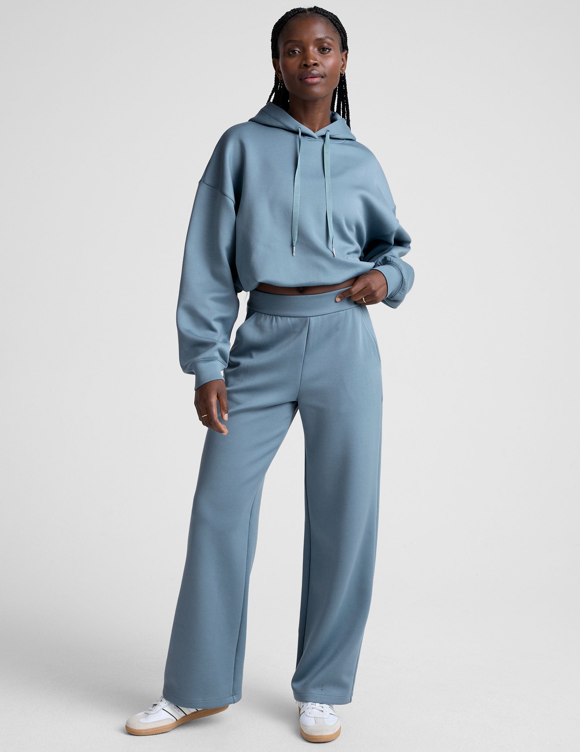 model is wearing blue spacer style pants with pockets against a plain background.