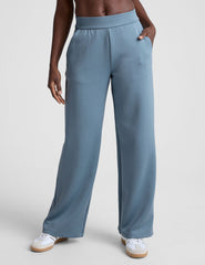 model is wearing blue spacer style pants with pockets against a plain background.