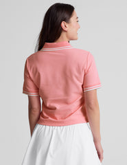 pink polo style top with a stripe rib collar and cuff , front placket with buttons, side slits, and hits at a high hip length. 