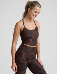 woman wearing a red and brown printed cropped tanks and leggings.
