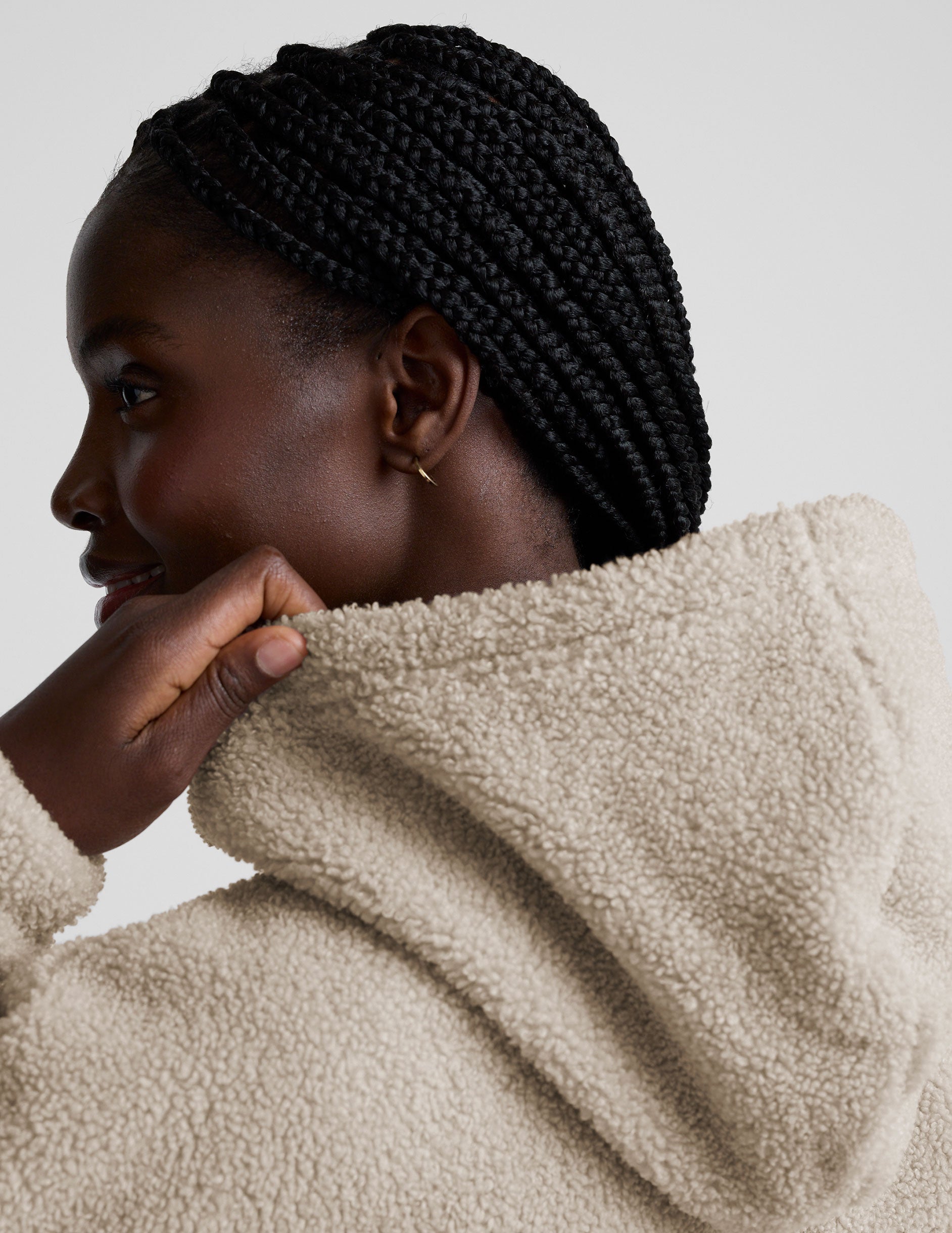 model wearing a beige fleece quarter zip pullover with a plain background.