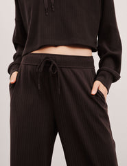 model wearing brown ribbed wide leg pants with a drawcord at waistband against a plain background.