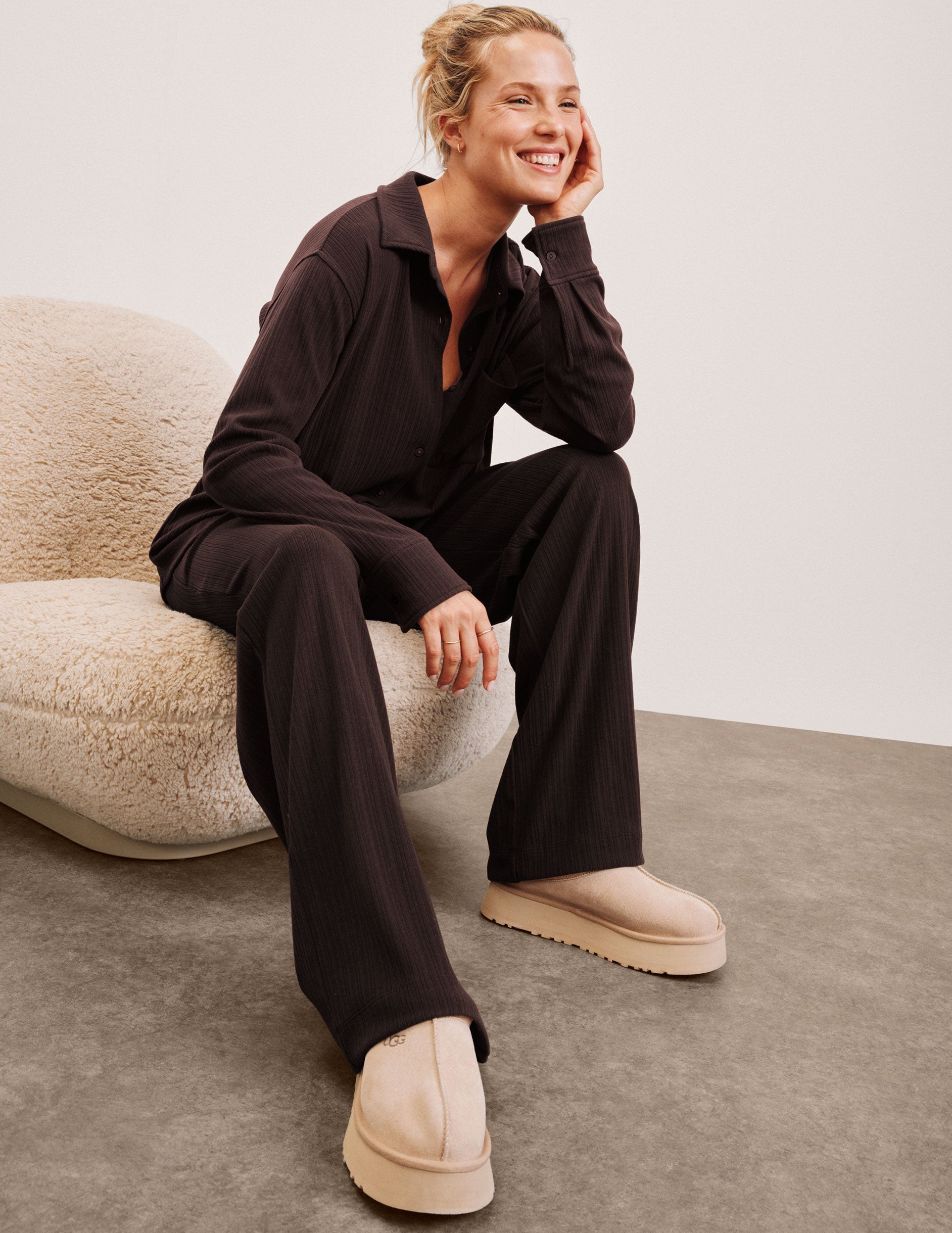 model wearing brown ribbed wide leg pants with a drawcord at waistband against a plain background.