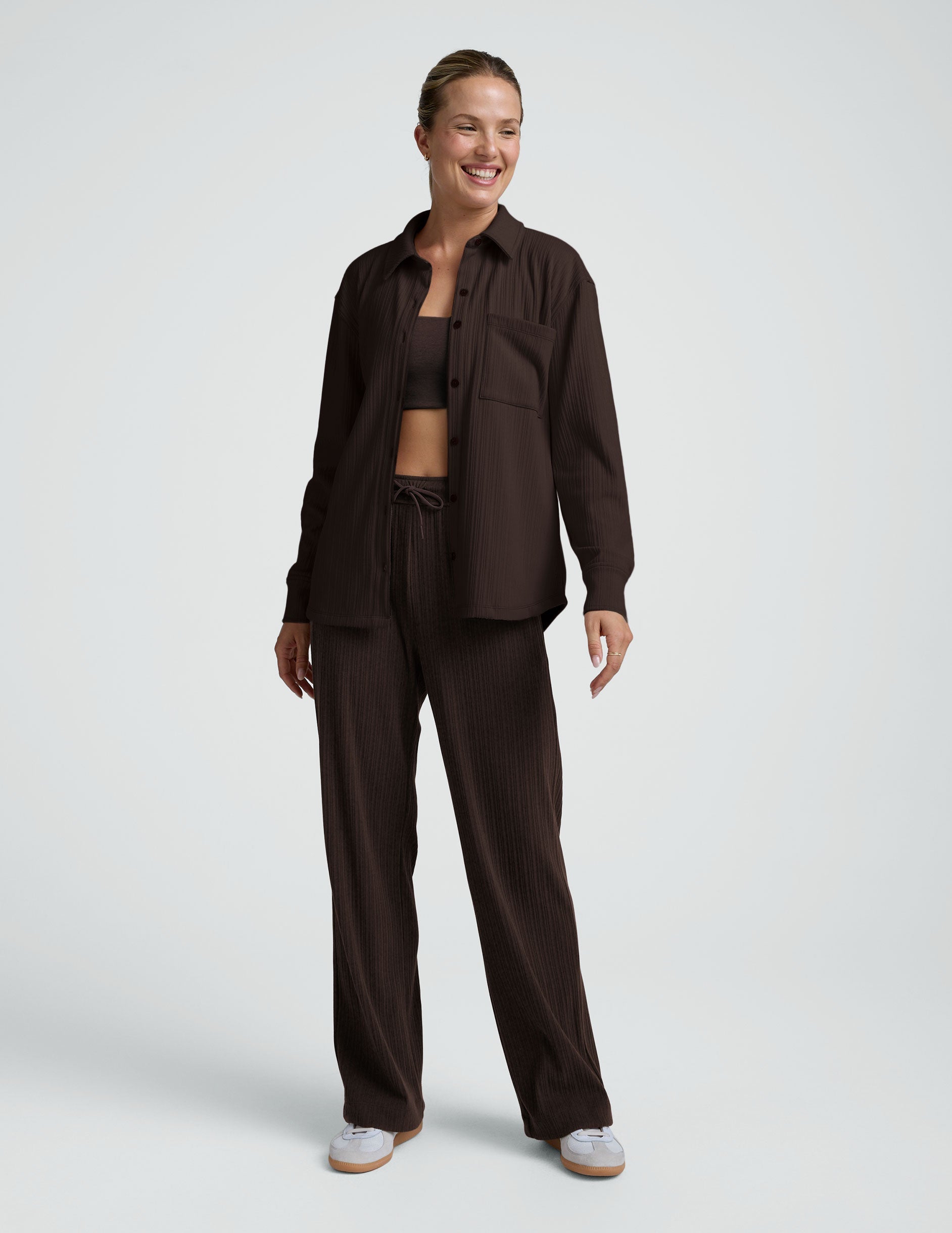 model wearing a brown ribbed button down top and brown ribbed pants against a plain background.