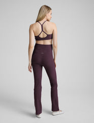 person wearing purple maternity bootcut style pants against a plain background.