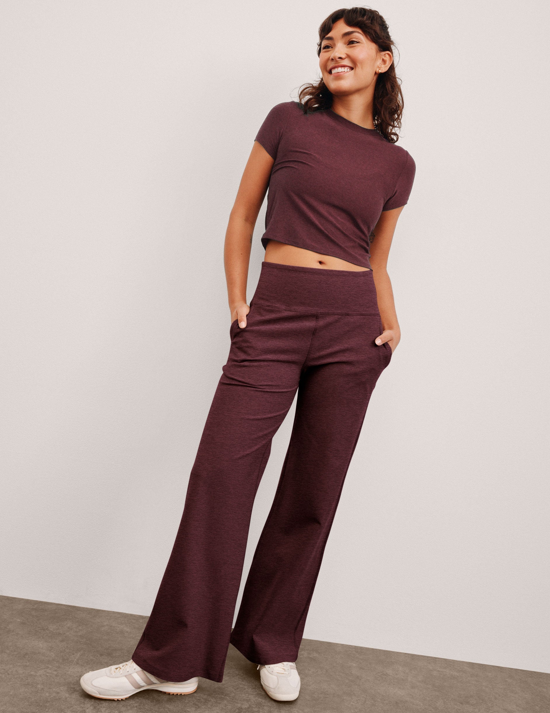 model is wearing red mid-rise wide leg pants with pockets.