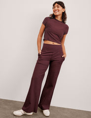 model is wearing red mid-rise wide leg pants with pockets.