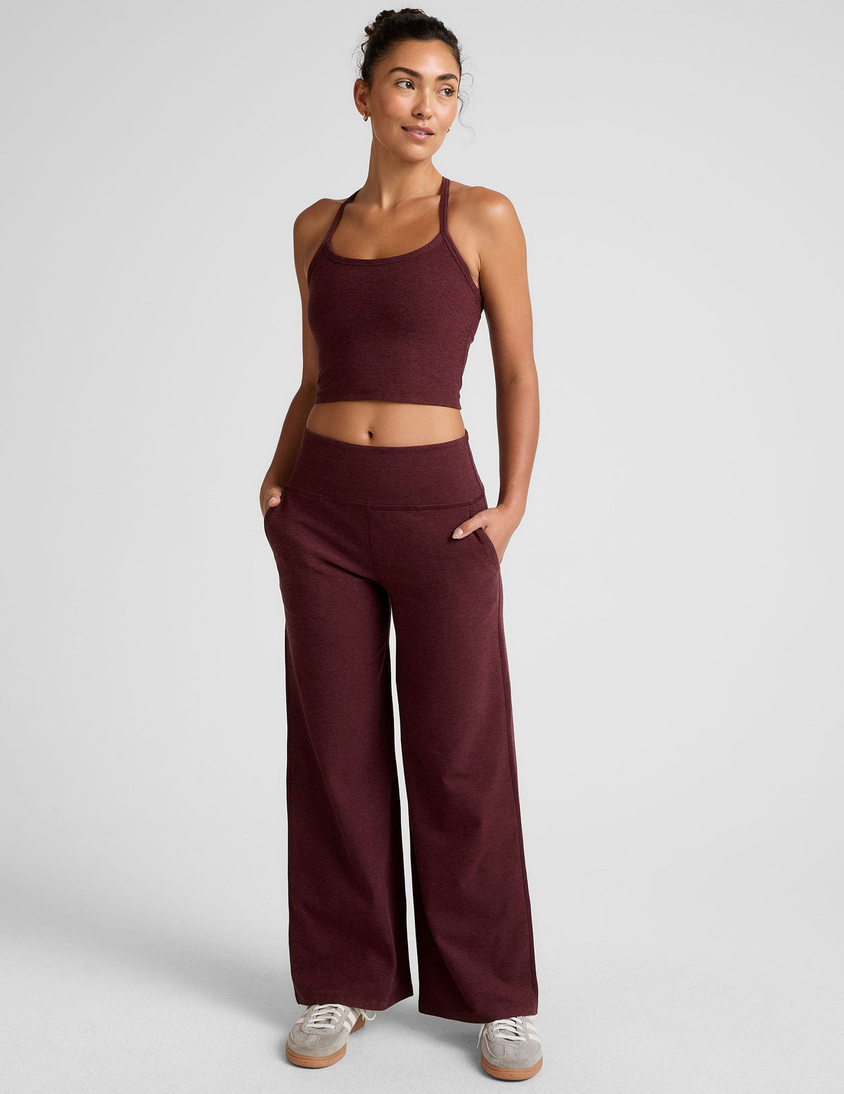 model is wearing red mid-rise wide leg pants with pockets.
